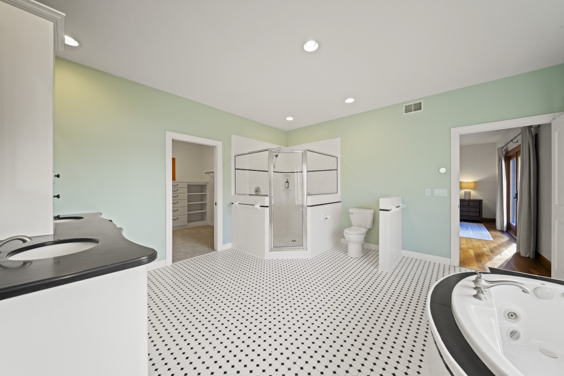 Luxury primary bathroom with dual vanities and heated floors